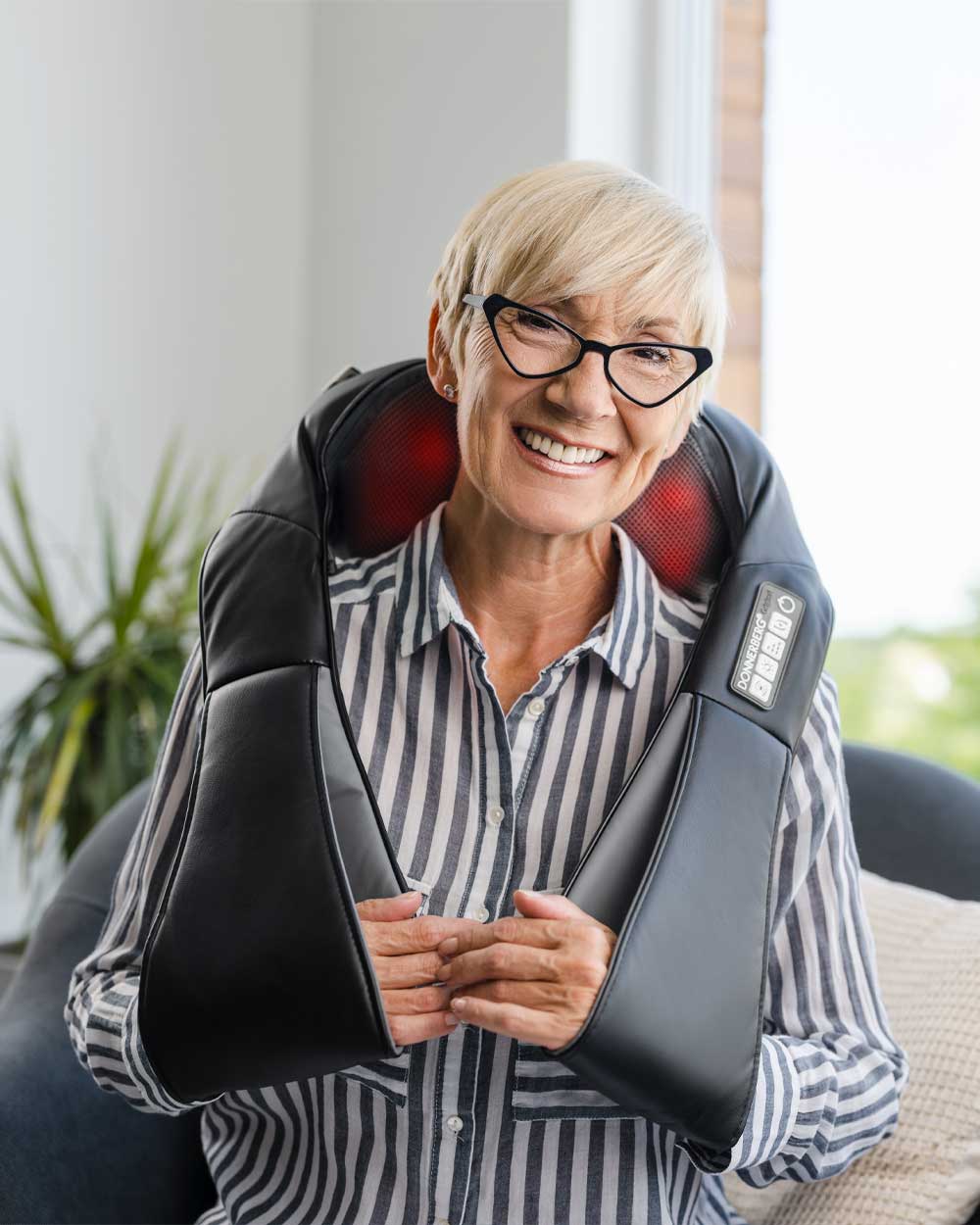 Oma massiert sich mit nackenmassagegerät