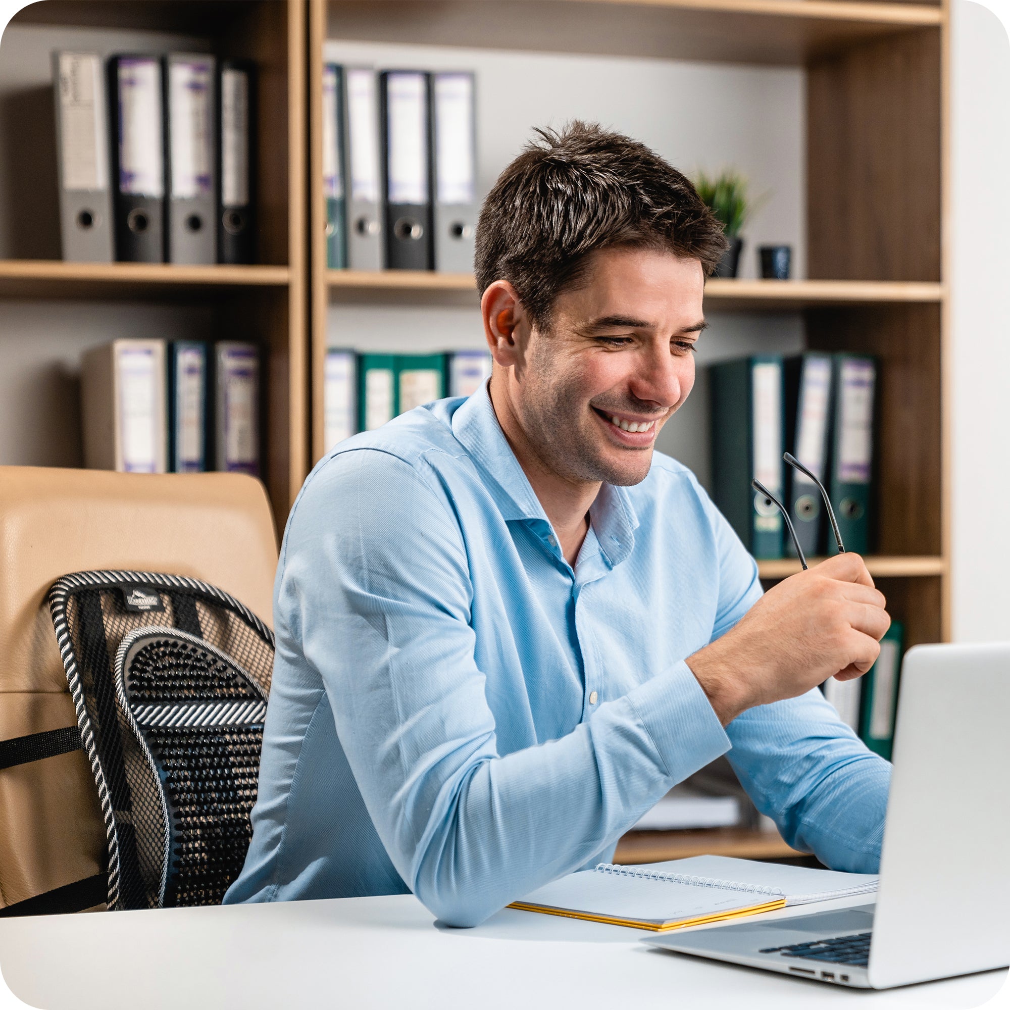 man at desk with lumbar back support on office chair