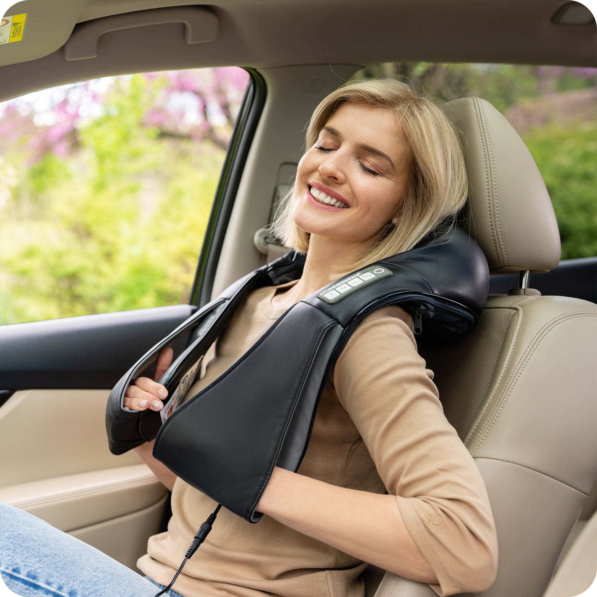 woman using electric neck massager in car