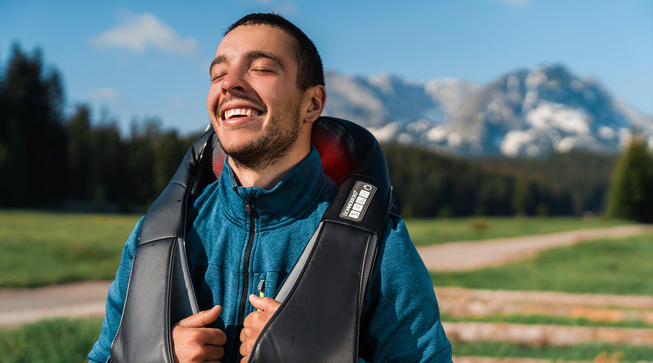 smiling man enjoying relaxing outdoor massage with neck and shoulder massager