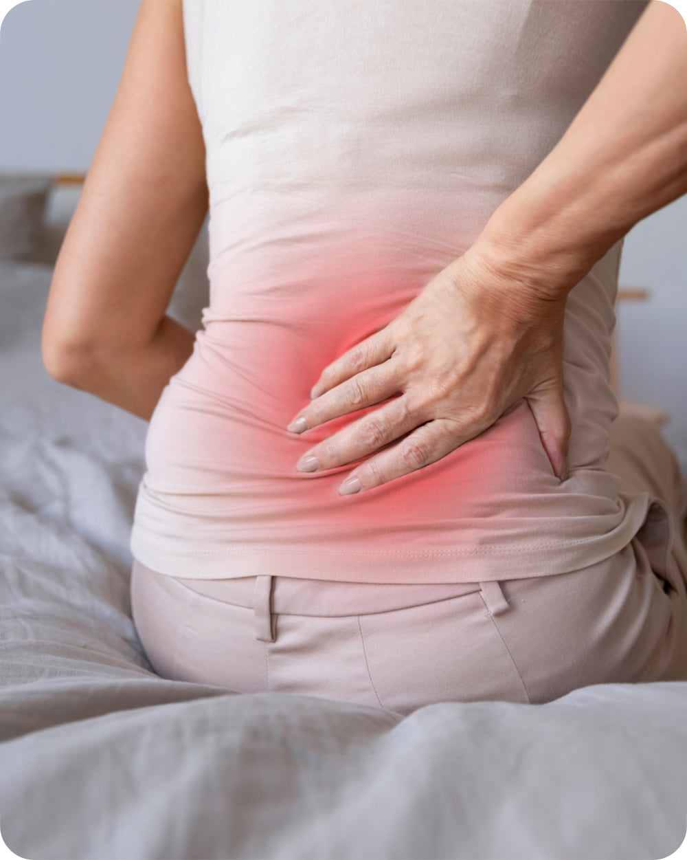 woman gripping her lower back tightly due to intense back pain