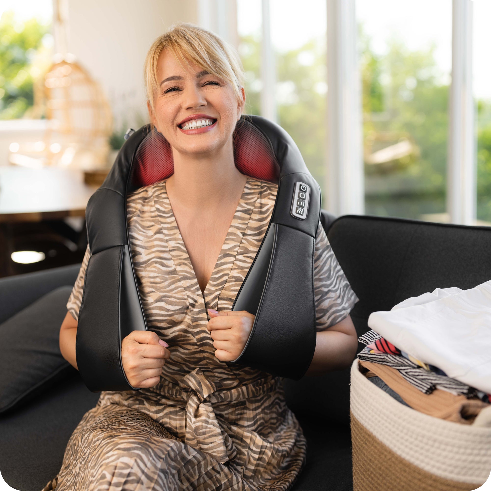 Smiling woman enjoying a relaxing massage with electric massager during a break from chores