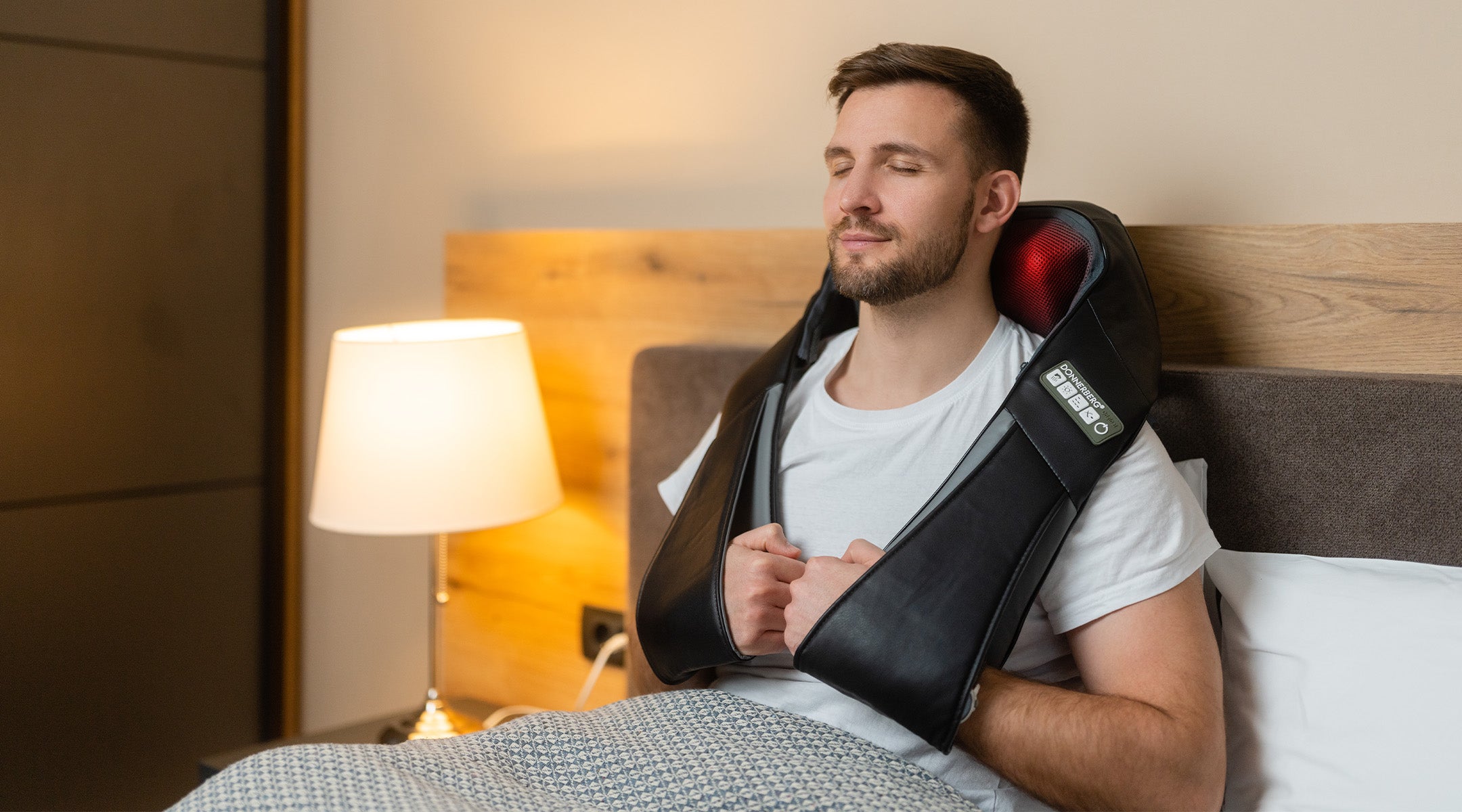 man experiencing blissful neck massage in bed with back and neck massager