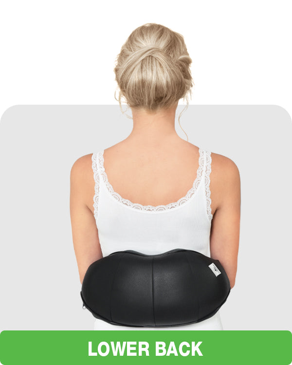 woman using shiatsu neck massager on her lower back