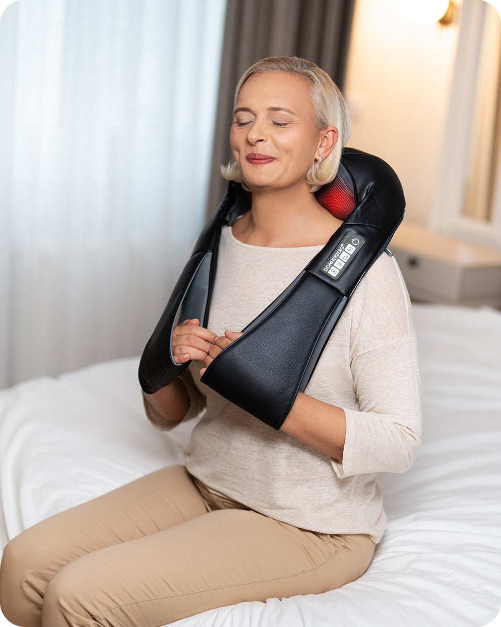 woman using neck and shoulder massager at home to relieve tension