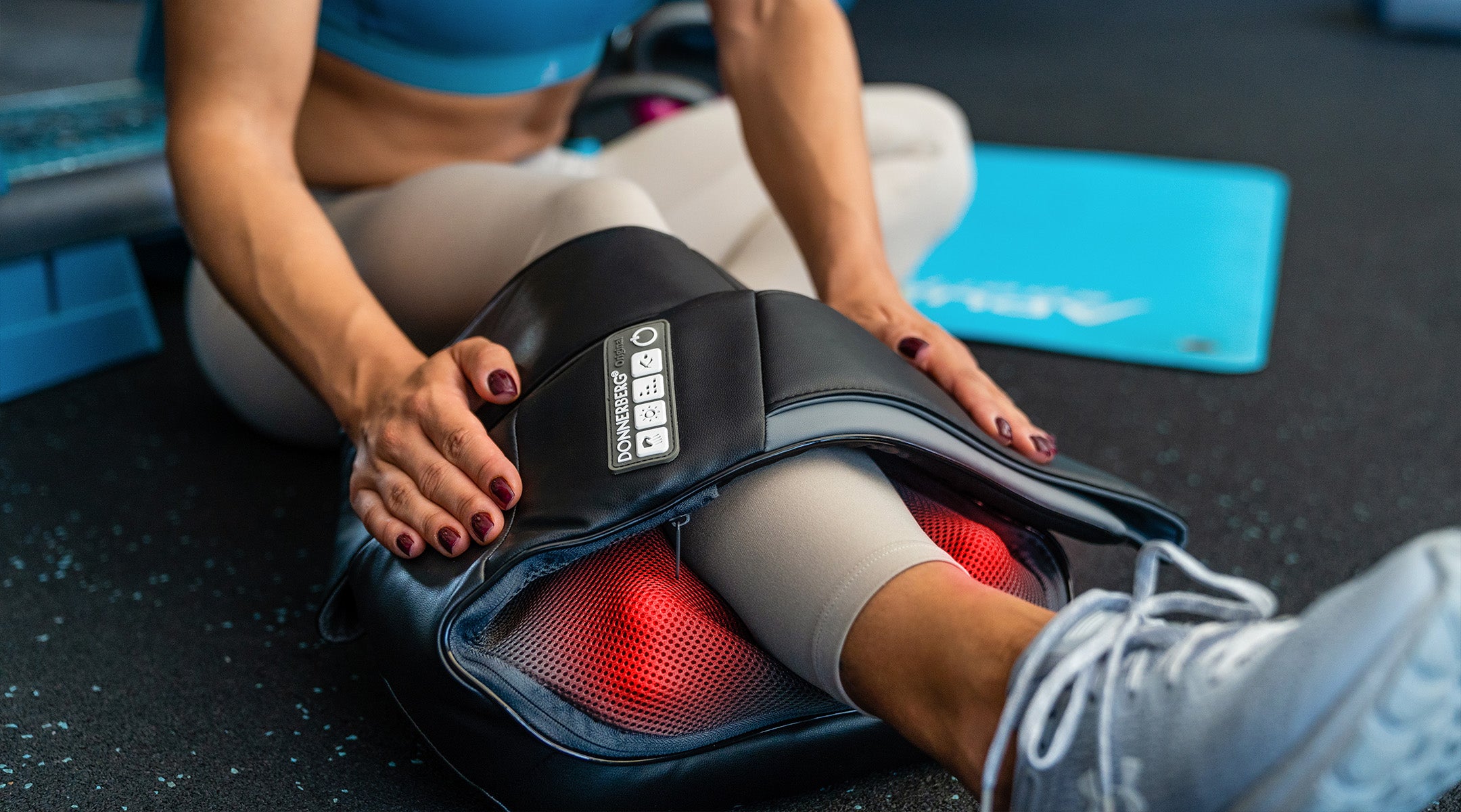 woamn in gym using back and neck massager with heat to relieve sore muscles