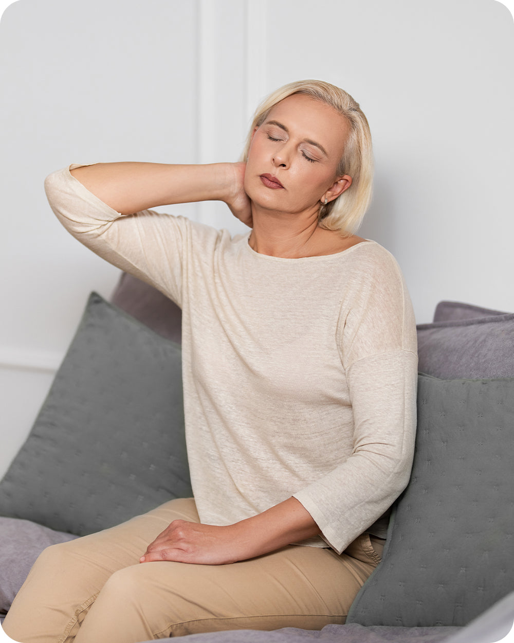 woman gripping on her stiff neck due to muscle pain